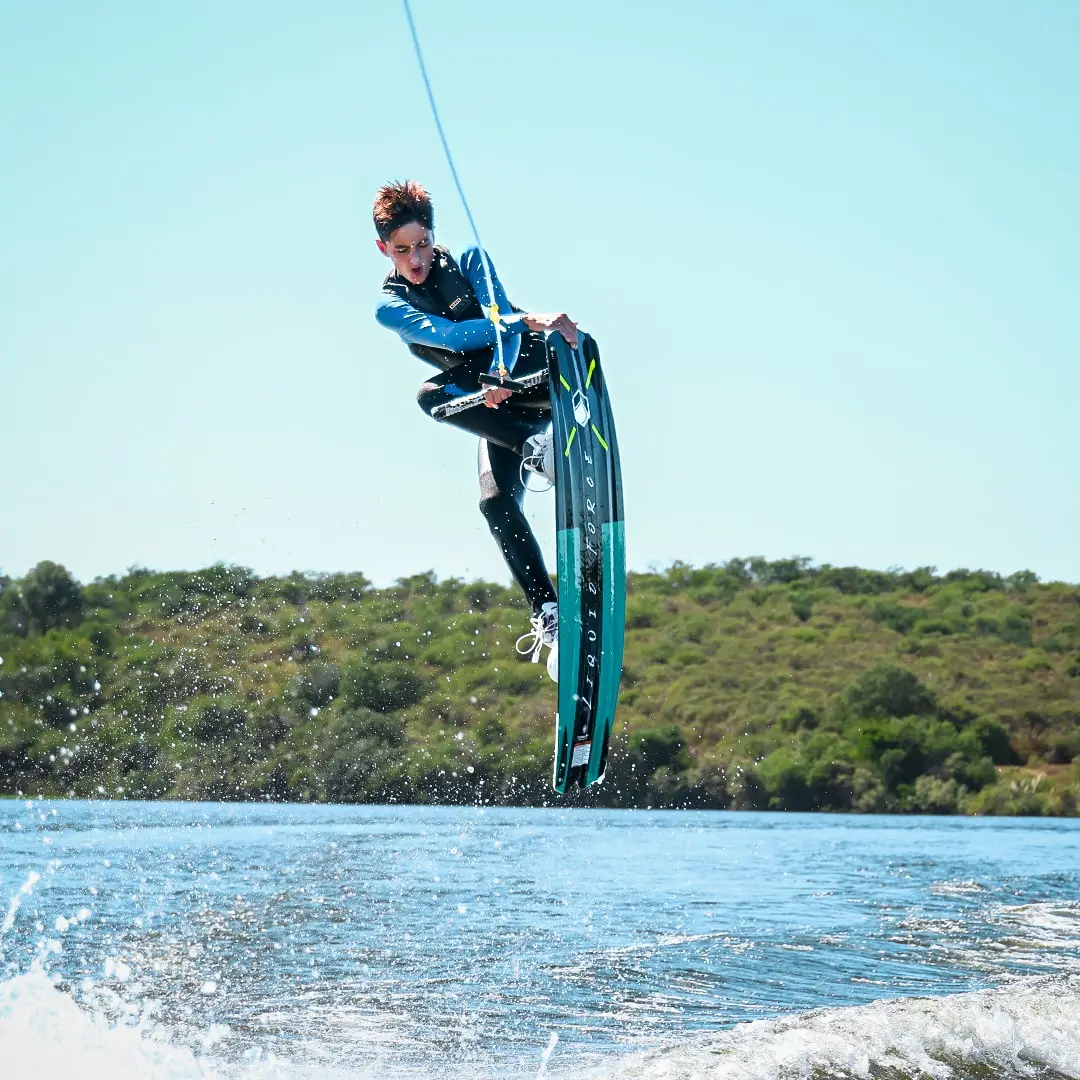 Wakeboarder en el aire sujetando la tabla