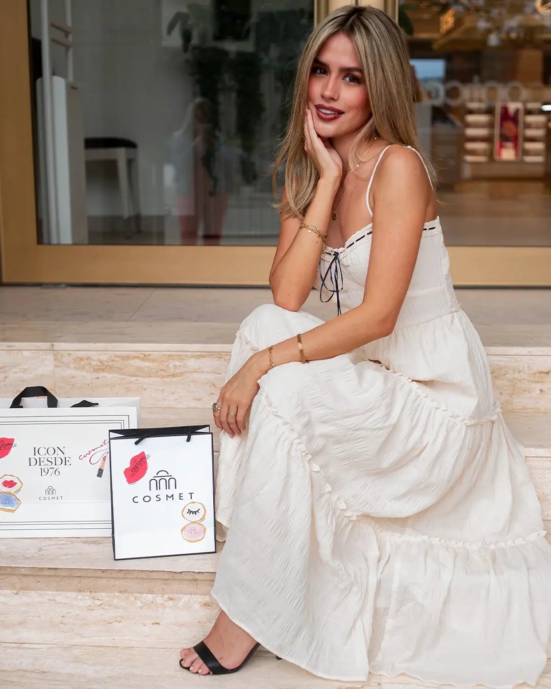 Modelo sentada en unos escalones con bolsas de compra
