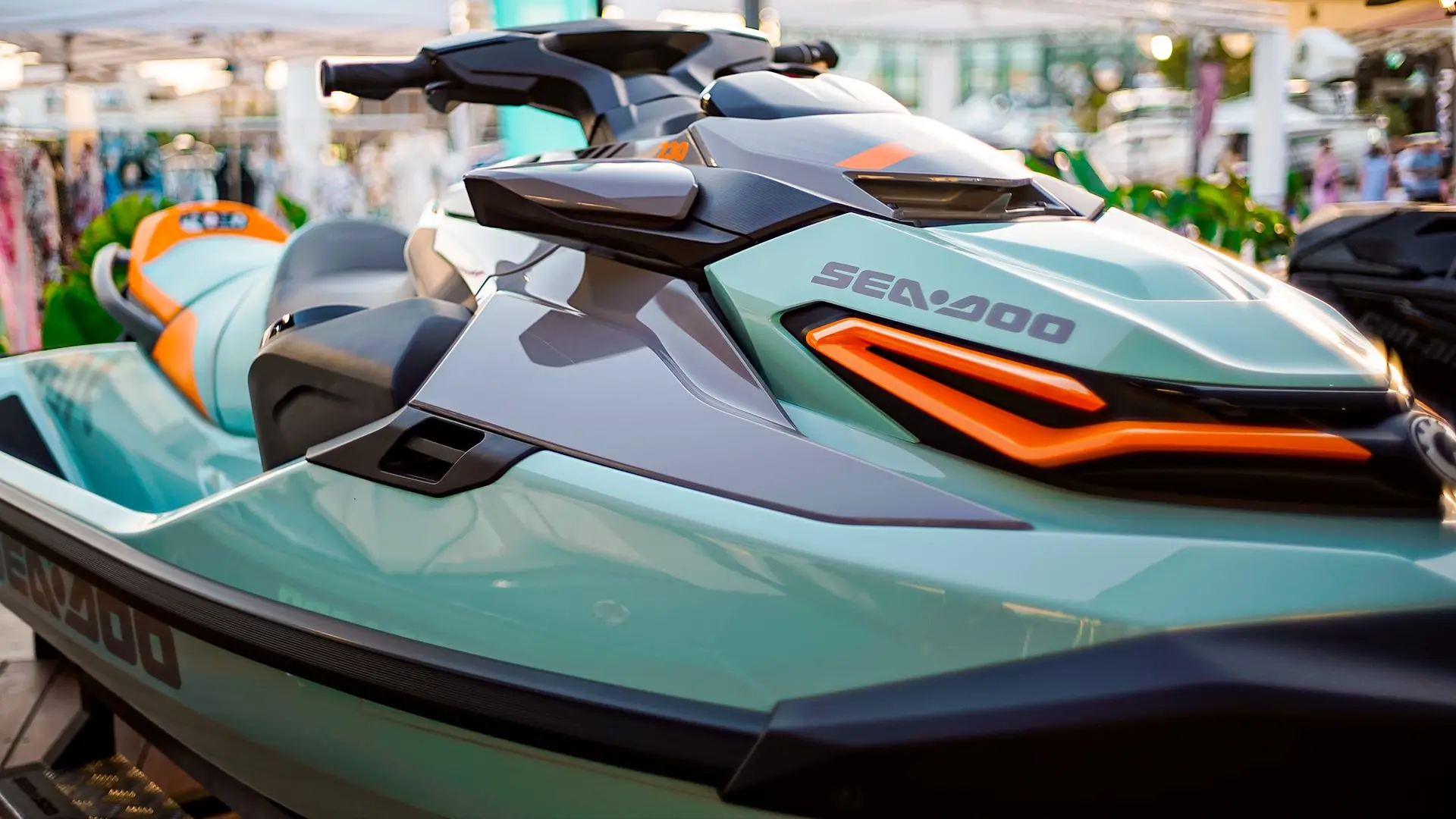 Moto de agua verde agua con detalles naranjas en un showroom