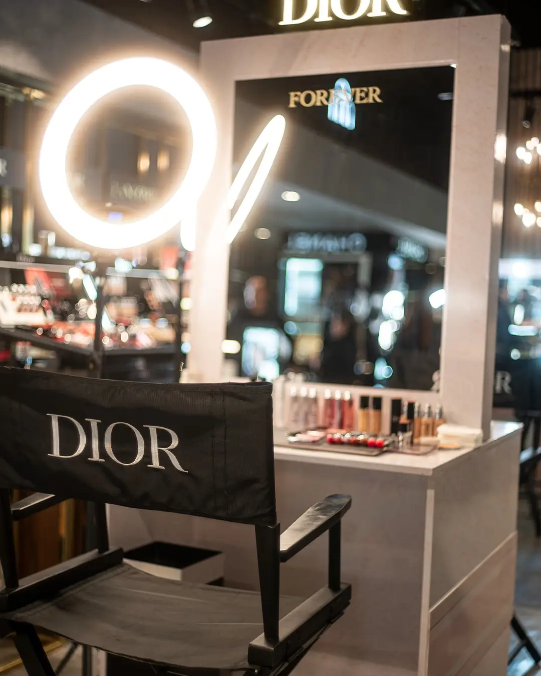 Silla de maquillaje vacía frente a un espejo con aro de luz
